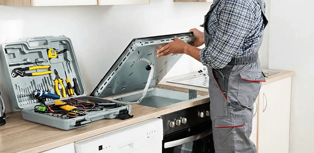 Handyman repairing a cooktop and checking wiring connections in Salt Lake City, UT