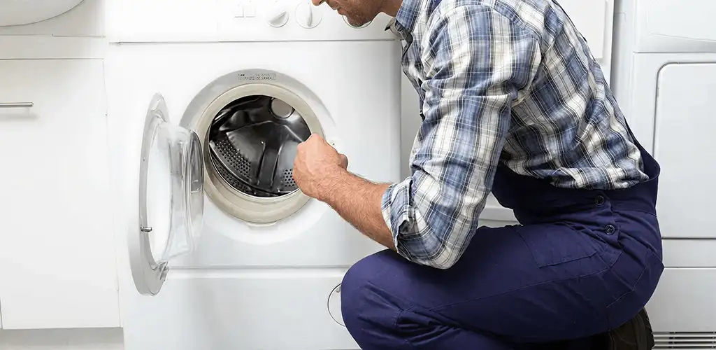 Handyman inspecting a dryer drum and internal parts for repair in Salt Lake City, UT