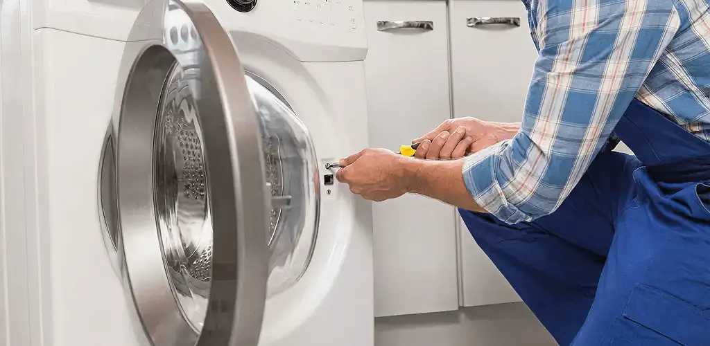 Handyman repairing a clothes dryer and checking electrical connections in Salt Lake City, UT