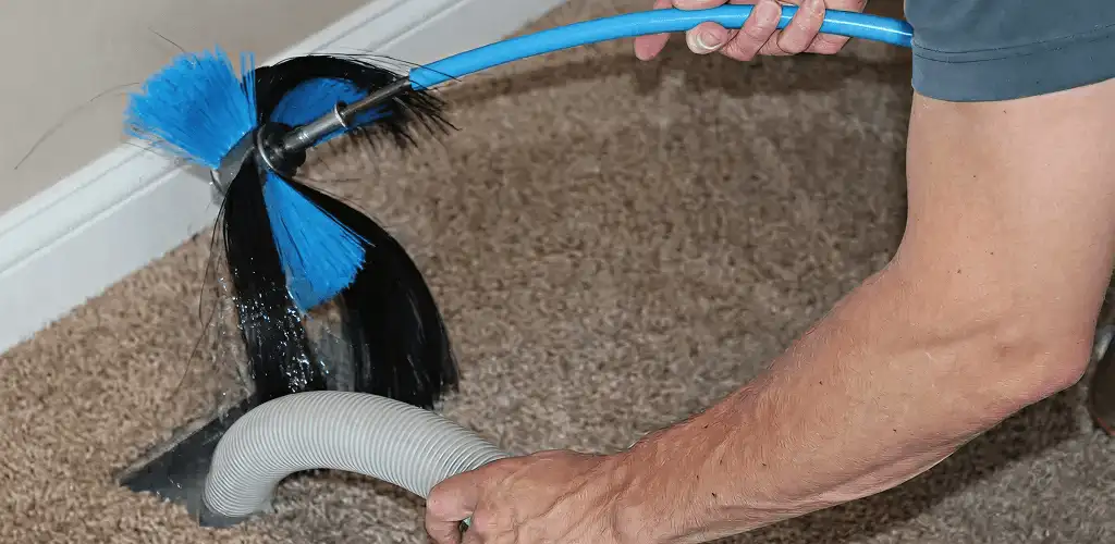 Dryer vent cleaning technician brushing lint from a vent line in Salt Lake City, UT