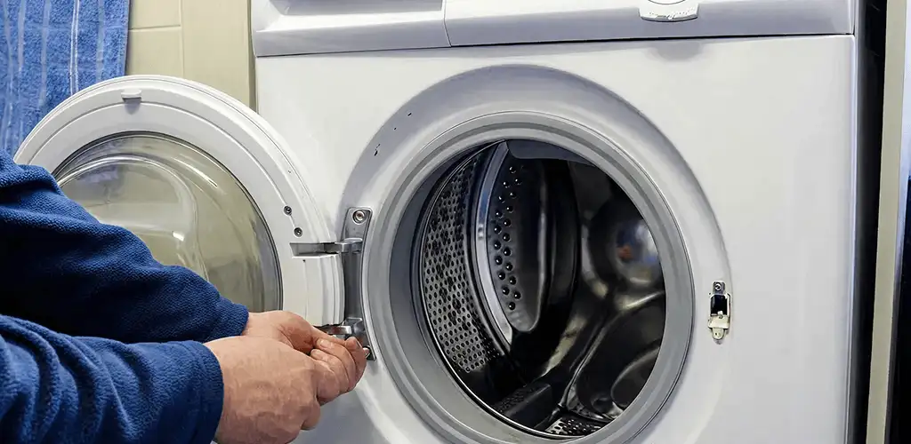 Washing machine repair handyman checking a front-load washer door and latch in Salt Lake City, UT