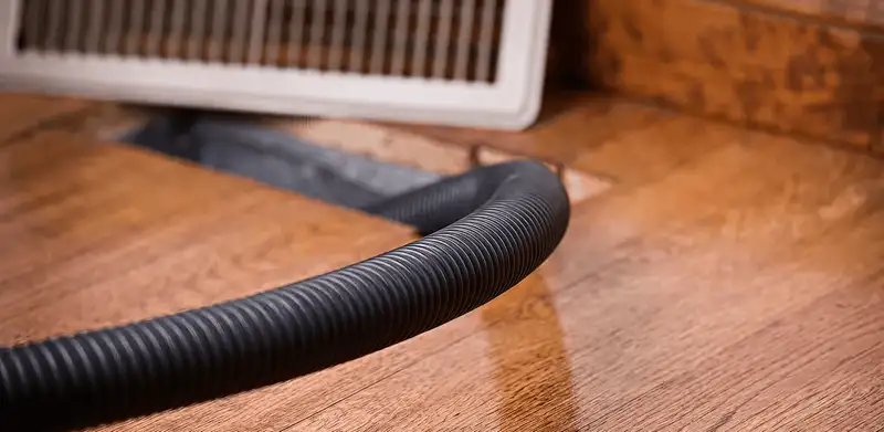 Air duct cleaning hose inserted into a floor vent for ductwork cleaning in Salt Lake City, UT