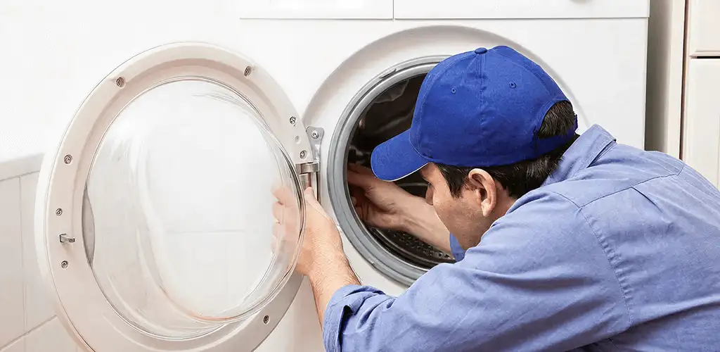 Washing machine repair handyman inspecting a front-load washer drum in Salt Lake City, UT