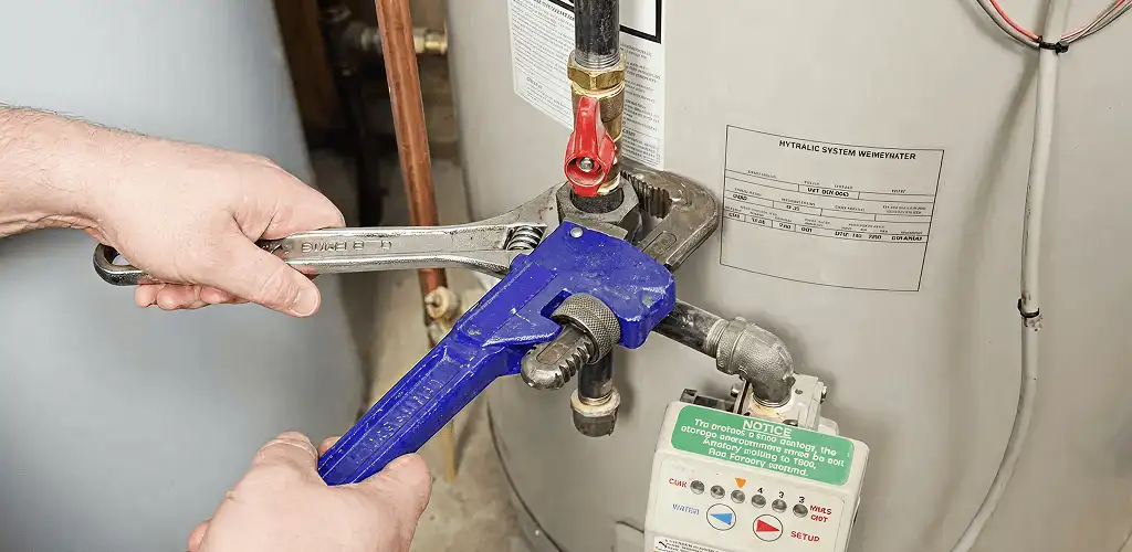 Water heater repair technician tightening the shutoff valve and supply line in Salt Lake City, UT